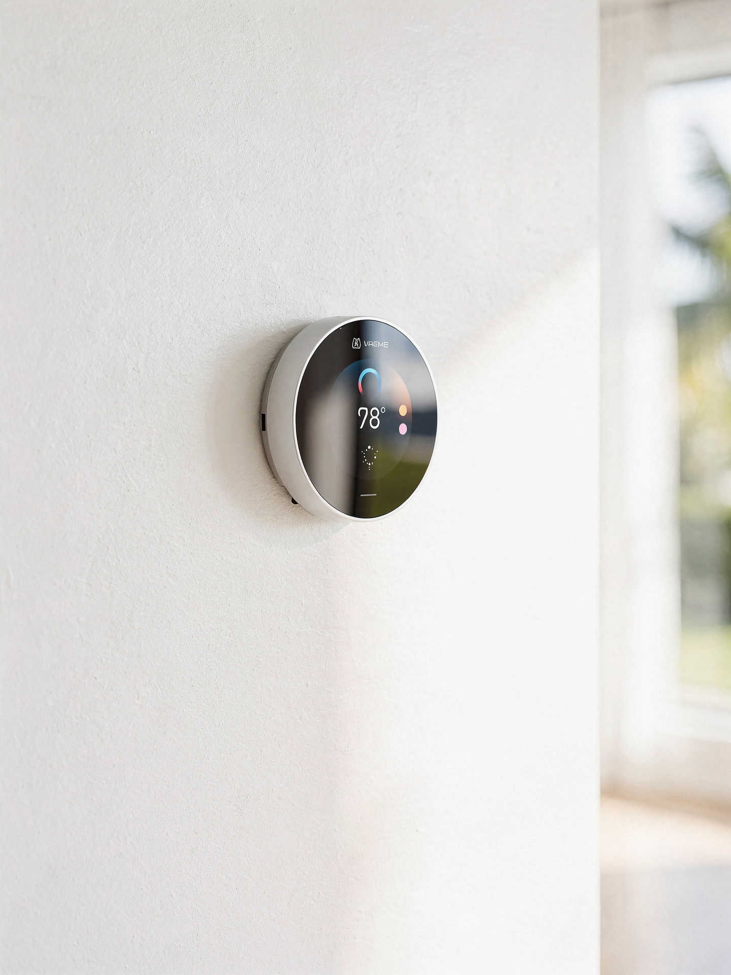 A modern smart thermostat set to a comfortable temperature on a softly sunlit wall